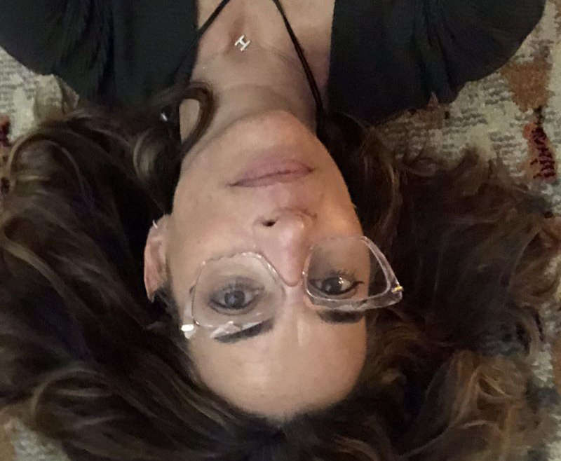 Dark haired woman on ground facing camera inside down