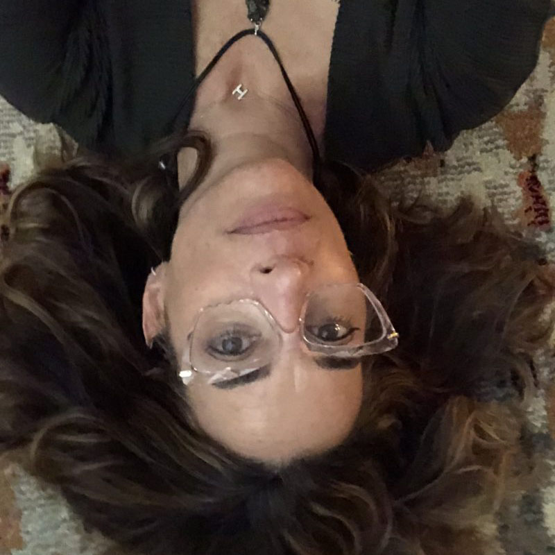 Dark haired woman on ground facing camera inside down